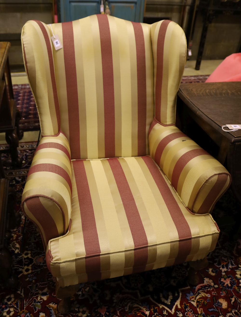 A 1920s wing armchair upholstered in striped fabric, width 80cm, depth 74cm, height 100cm